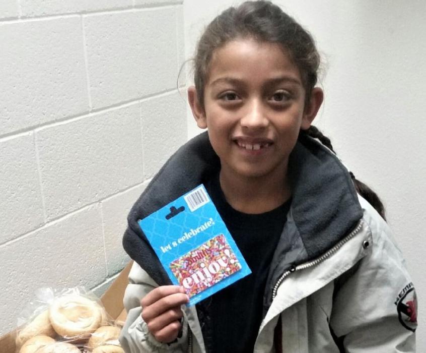 CHS' NHS presenting Mark Twain Elementary Student Angel with a card to purchase a turkey for Thanksgiving last year.