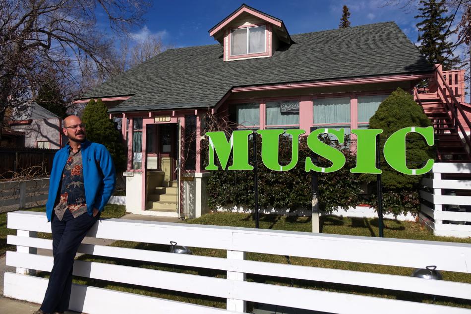 Vince Gates takes a break outside of his music store, Play Your Own Music