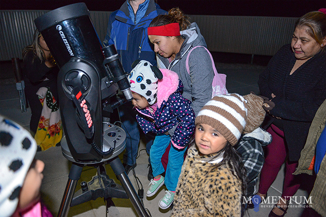 Nereida Burgara helps Zuleyka Hernandez, 3, look through a telescope.  Photo: Tim Dunn