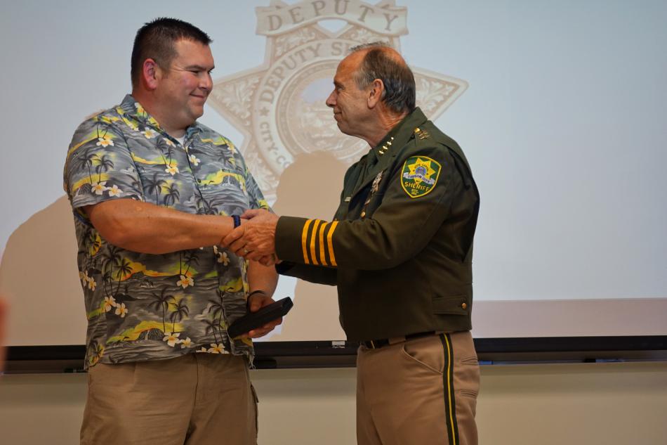 Deputy Chris Rivera (left) receives one of his 3 awards from Sheriff Ken Furlong
