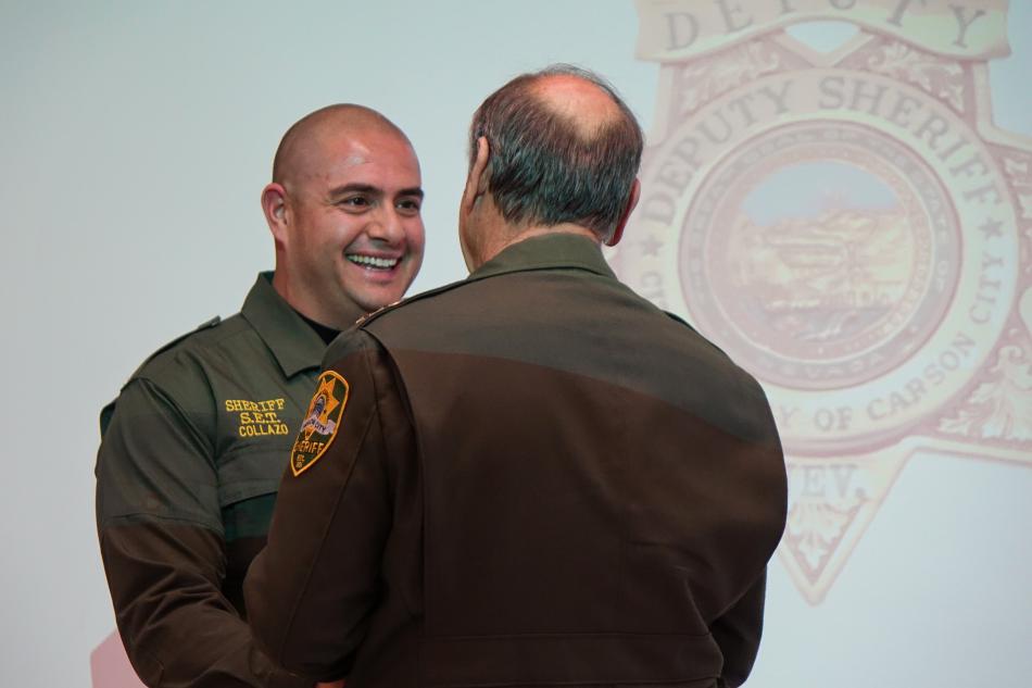 Deputy Uriel Collazo (left) shakes Sheriff Ken Furlong's hand as he receives the Lifesaving Award