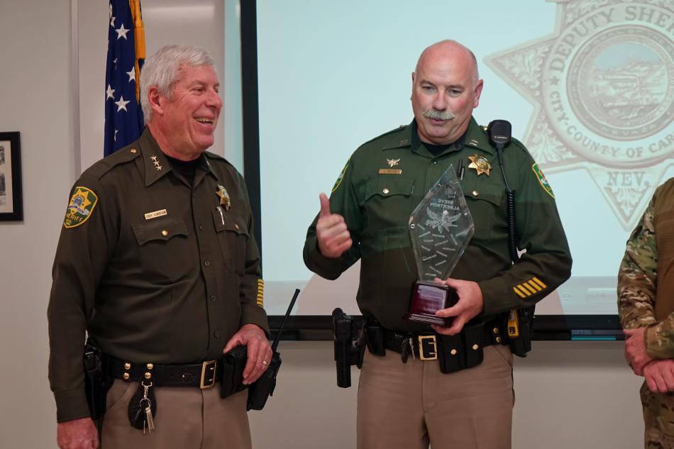 Undersheriff Steve Albertsen accepts a plaque from Captain Jeff Melvin on behalf of the S.W.A.T. team