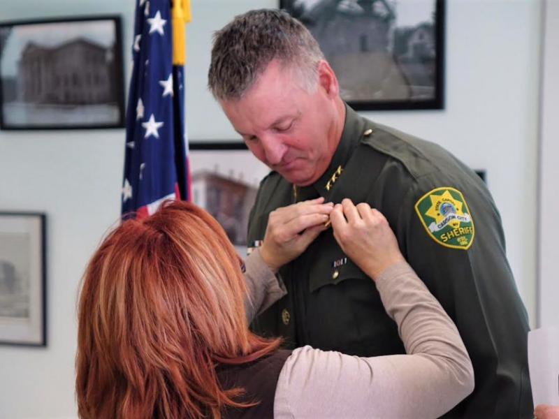 Photos by Jim Gustafson. Undersheriff Ken Sandage has his badge pinned on Thursday.