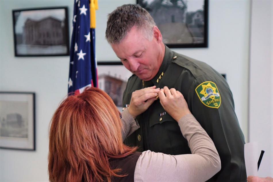 Photos by Jim Gustafson. Undersheriff Ken Sandage has his badge pinned on Thursday.