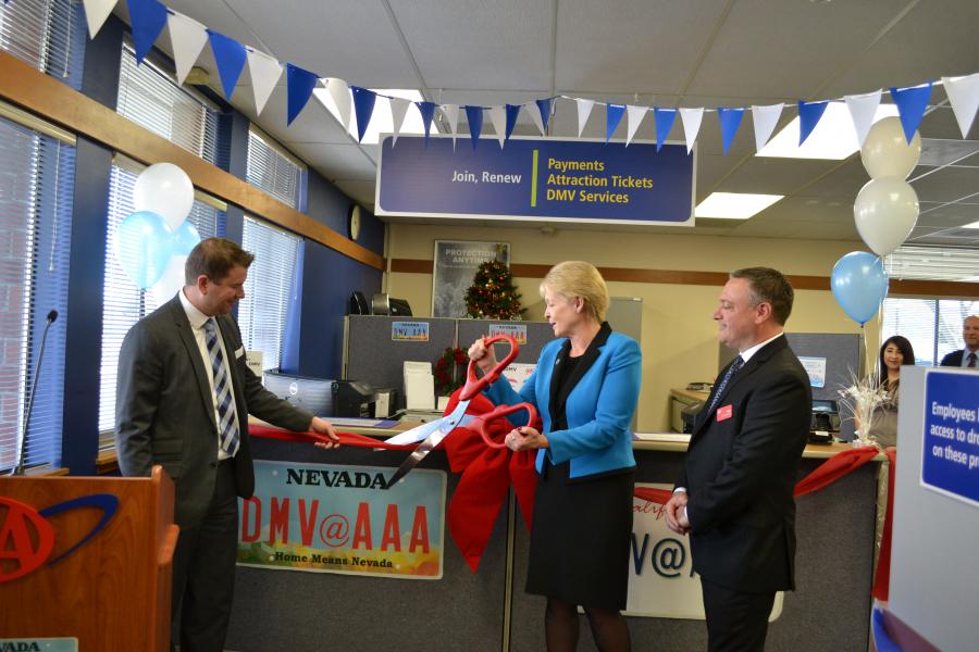 DMV Director Terri Albertson cuts the ribbon alongside AAA's Brian MacAdam and John Cruger.