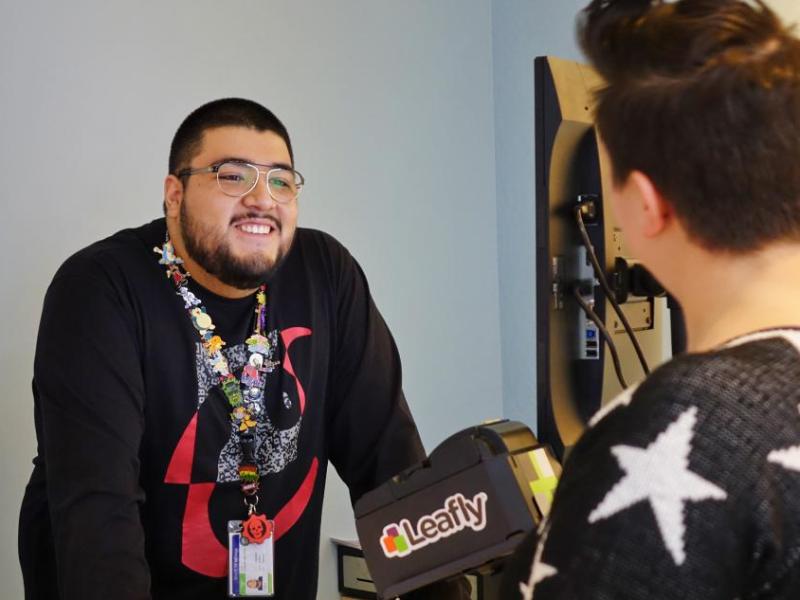 A "budtender" at Sierra Wellness greets a customer.