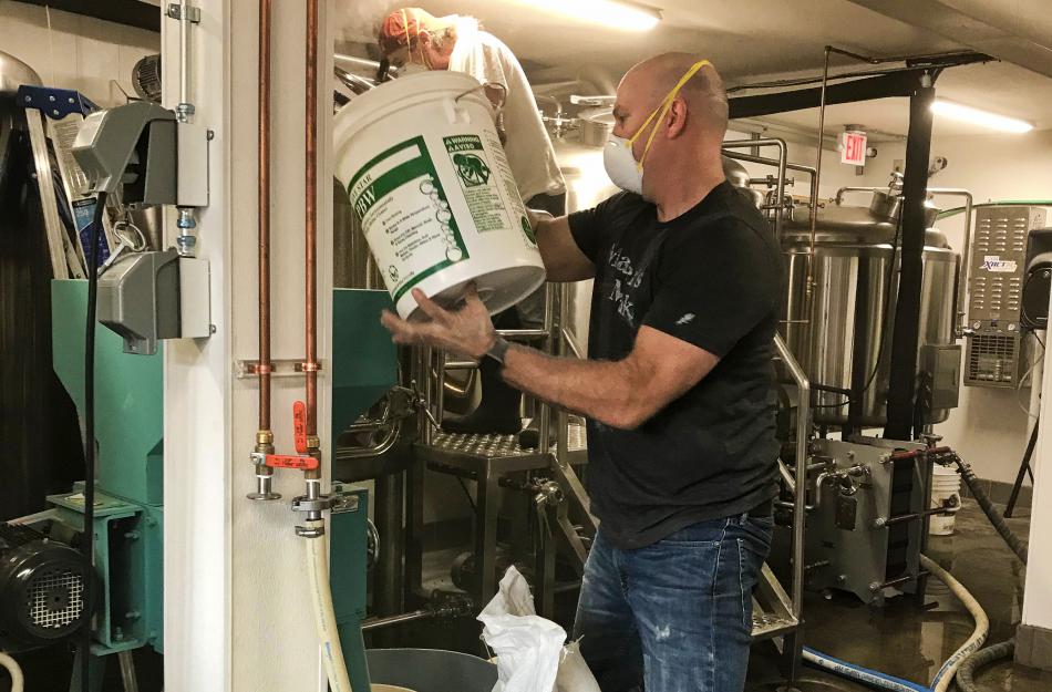 Owner, Jim Phalan, pours grain for a brew.