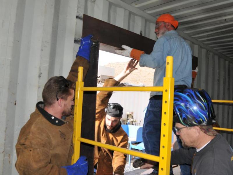 Michael Varner, Charles Carnevale and Eric Forstrom assist Masih Madani, on the home he is building out of a shipping container.