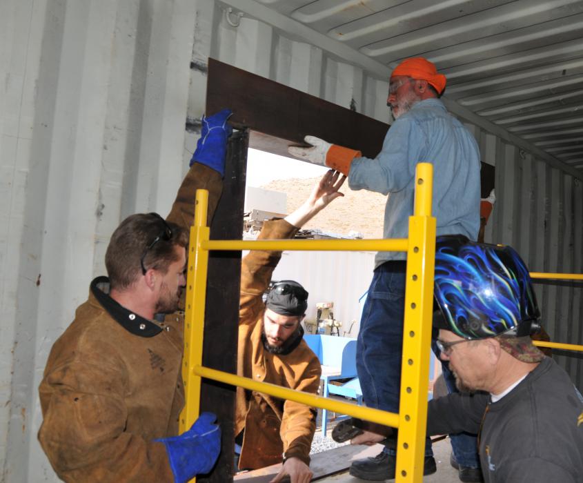 Michael Varner, Charles Carnevale and Eric Forstrom assist Masih Madani, on the home he is building out of a shipping container.
