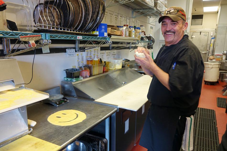 Chef Mickey Woomer preps some dough with a smile