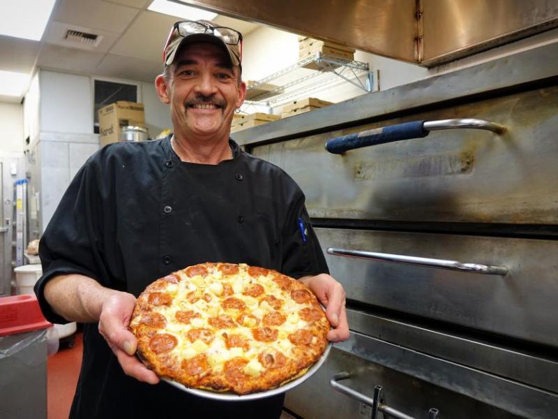 Head Chef Mickey Woomer presents a pizza, fresh out of the oven.