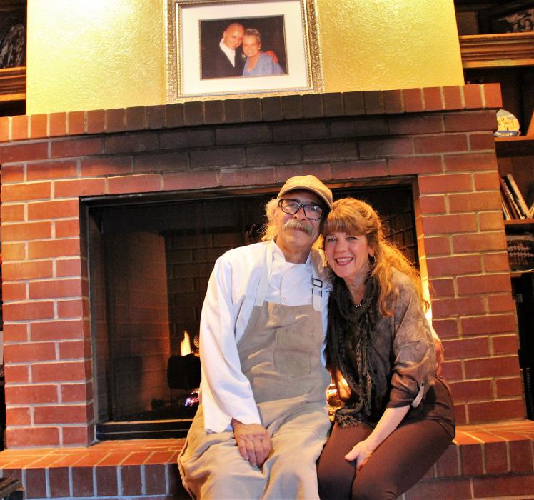 Photo by Brett Fisher. Charlie and Karen Abowd sit in front of the fireplace inside Adele's.