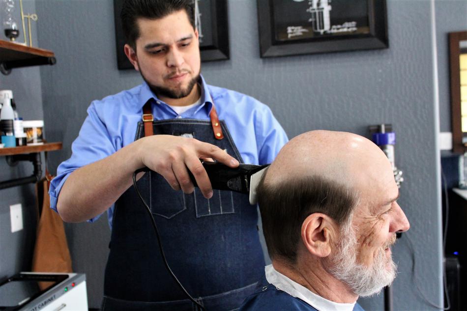 Nick Fontanez trims hair on first-time customer John Bartlett of Reno.