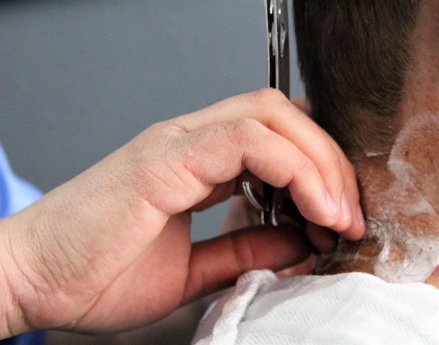 Nick Fontanez uses a straight razor on customer John Bartlett.