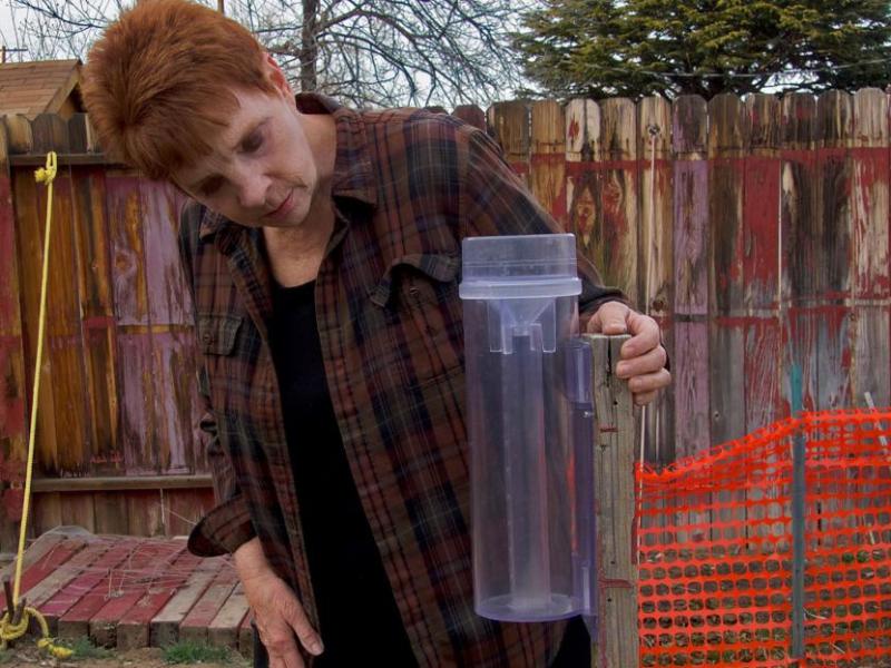 Volunteer weather observer Janet O’Neill takes a measurement using a rain gauge. Photo by Kerri Jean Ormerod