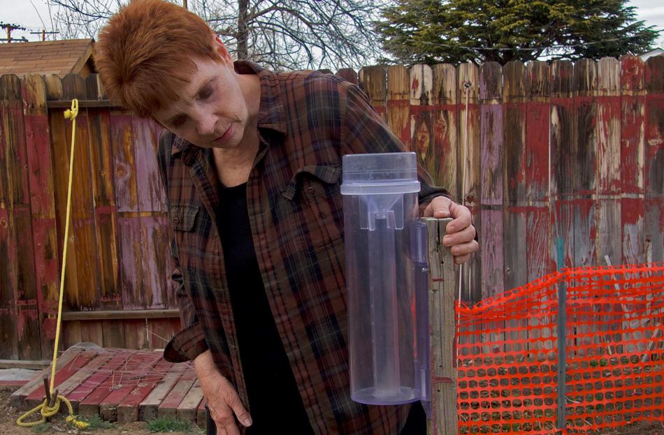 Volunteer weather observer Janet O’Neill takes a measurement using a rain gauge. Photo by Kerri Jean Ormerod