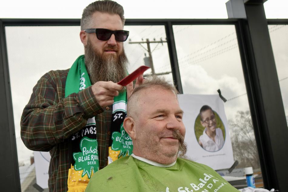 Barber Jeremy Root-Ferguson buzzing retired East-Fork Fire Captain John Bellona.