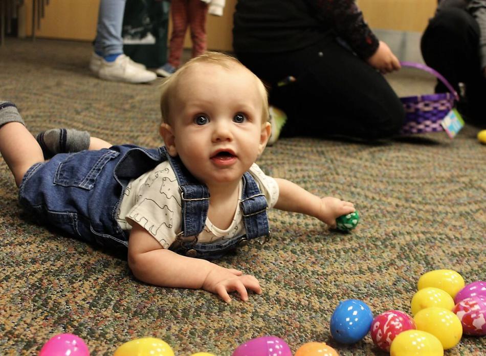 An infant reaches for Easter eggs spread out on the floor inside Carson Tahoe Hospital.