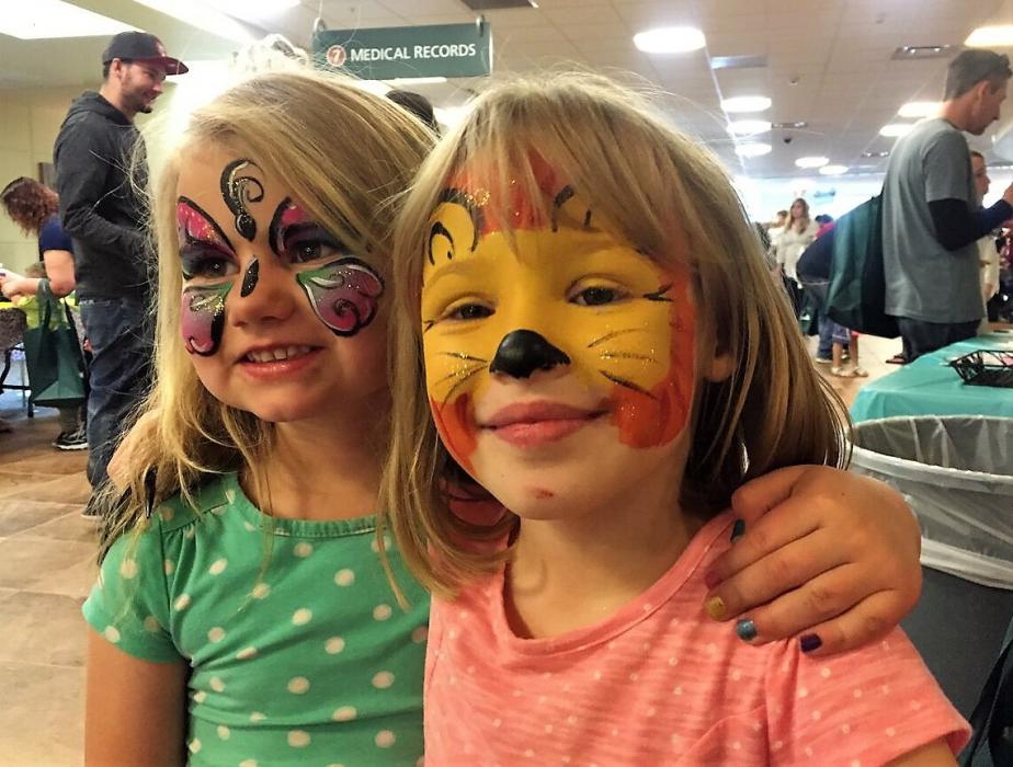 Two girls show off their face paintings Thursday at Carson Tahoe Hospital.