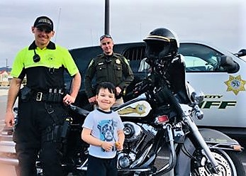 Photos by Dayzee Ramirez. Matthew Ramirez, 3, with Sheriff's deputies and their vehicles.