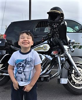 Matthew Ramirez, 3, with Carson City Sheriff's vehicles.