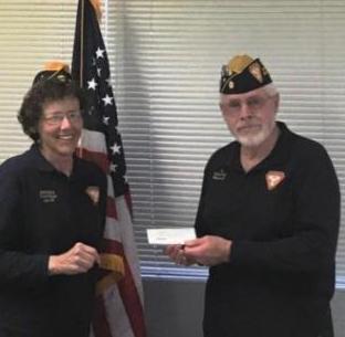 Brenda Horton, president, presents a check to Northern Nevada Honor Guard Commander Jim Jackson.