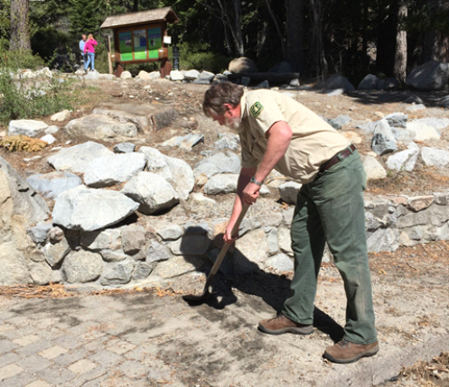 Mike Rhea of the Forest Service removes debris from the walkway at Eagle Falls Trailhead parking area. Photo: Brian Homberger