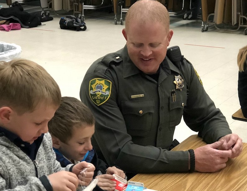 Deputy Sheriff Nick Pinochi sits with 2nd graders.