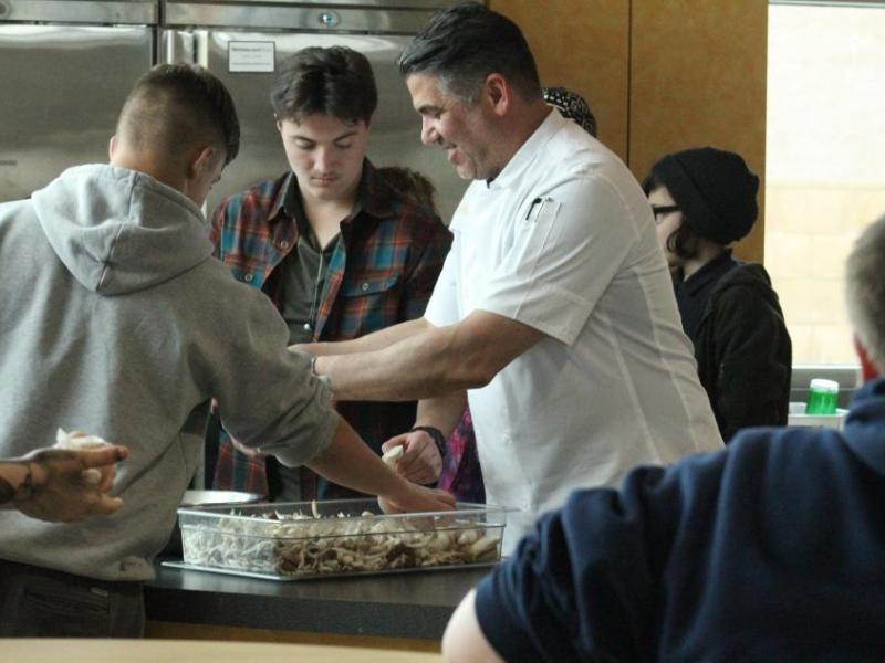 Mark Estee, chef and restaurateur, shows Boys & Girls Clubs Teen Center members how to break apart local mushrooms.