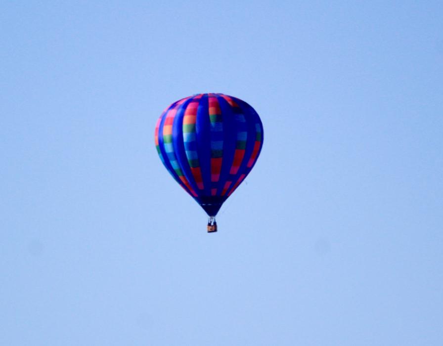 A third hot air balloon floats above South Carson City Sunday morning.