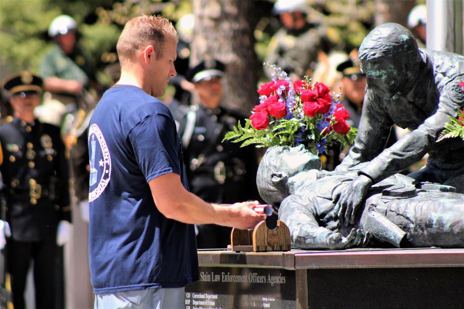 Photos by Brett Fisher. The baton with fallen officer names inscribed on it is placed upon the memorial Thursday.