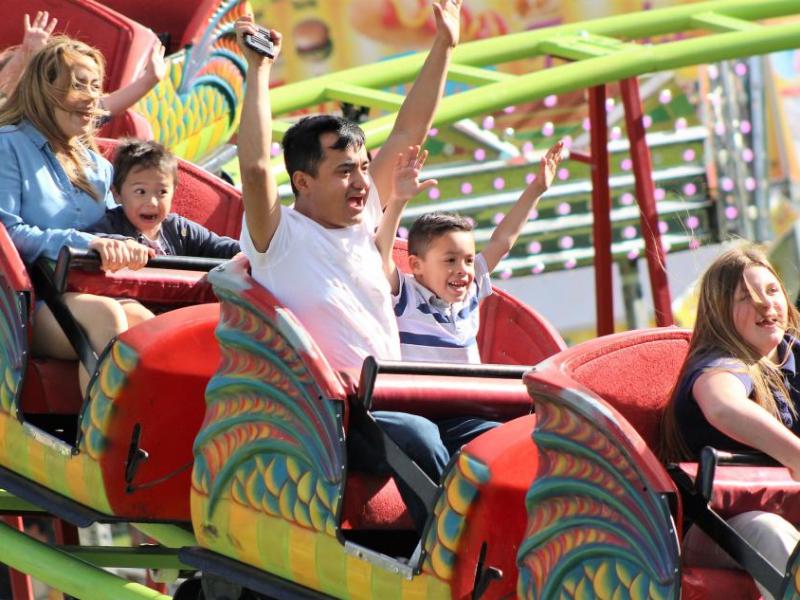 Photos by Brett Fisher. A family enjoys a roller coaster ride at Mills Park.