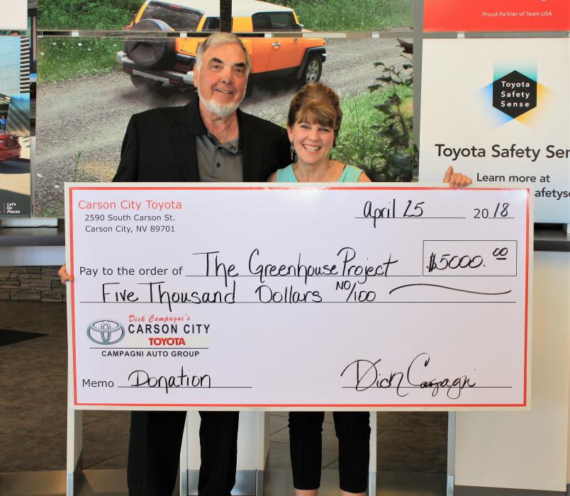 Dick Campagni presents a check to Karen Abowd of The Greenhouse Project.