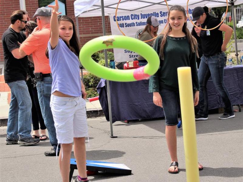 A girl performs the ring toss during the Cops and Kids Sheriff's Open House Saturday.