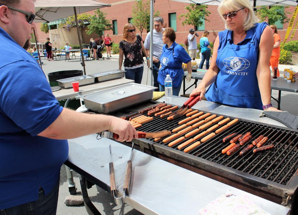 Dozens of hot dogs are prepared on a grill Saturday at Harbin and Musser streets.