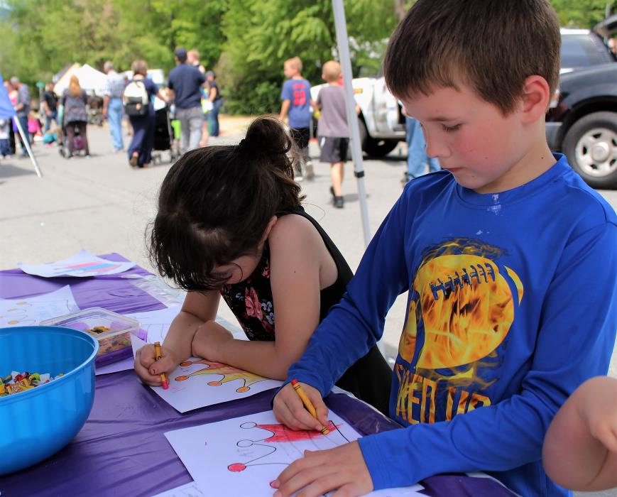 Children color at a booth along East Musser Street Saturday.