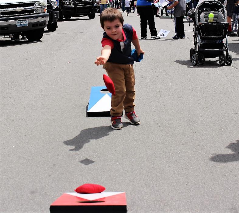 A boy plays the bean bag toss on East Musser Street Saturday.