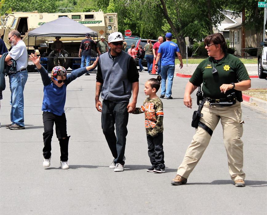 Photos by Brett Fisher. A youth and a Sheriff's deputy dance to music Saturday along East Musser St.