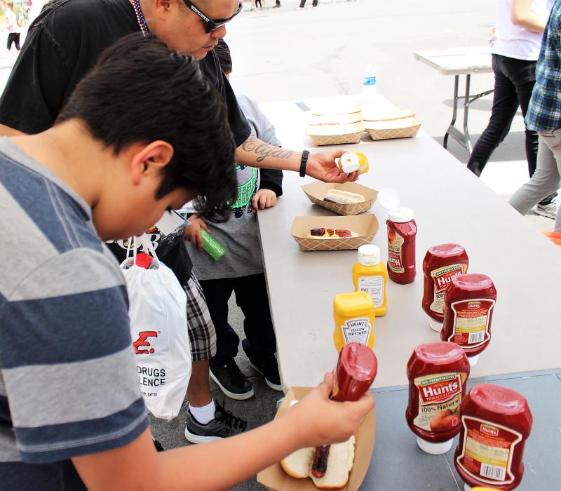Guests put condiments on their hot dogs Saturday during the Sheriff's Open House.