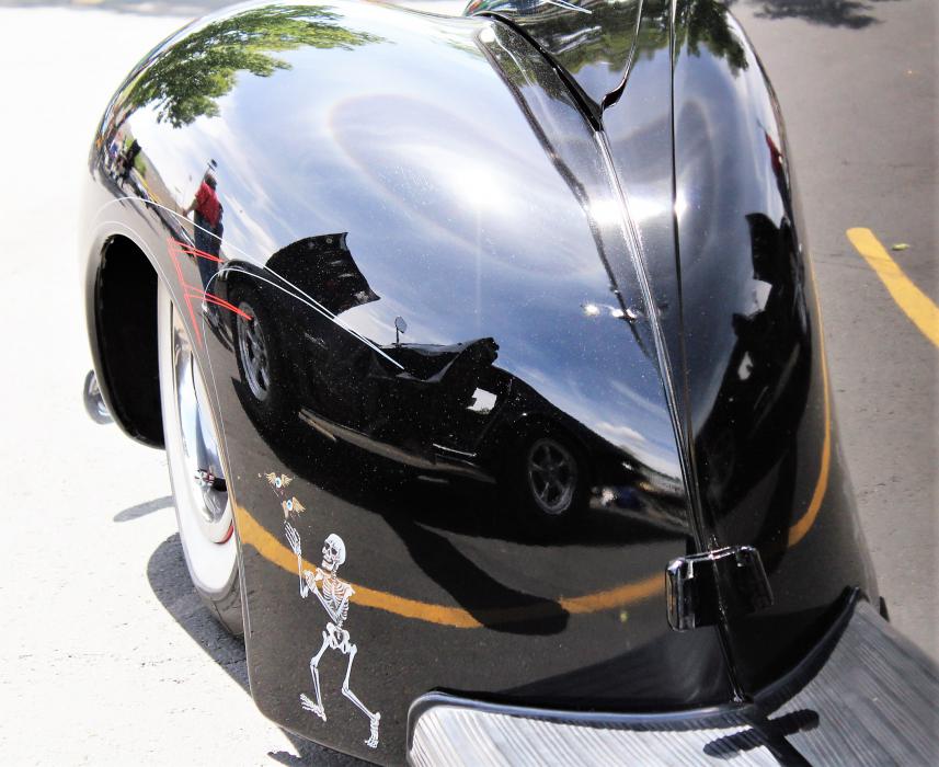 Reflection of a classic Chevrolet Corvette Stingray from the fender of a neighboring 1949 Ford.