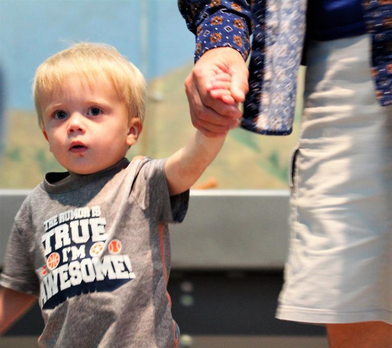 A toddler moves around in wagon fashion during a song.