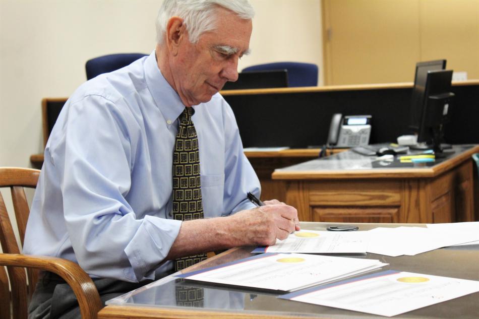 First Judicial District Court Judge James T. Russell signs certificates for each CASA guardian ad litem.