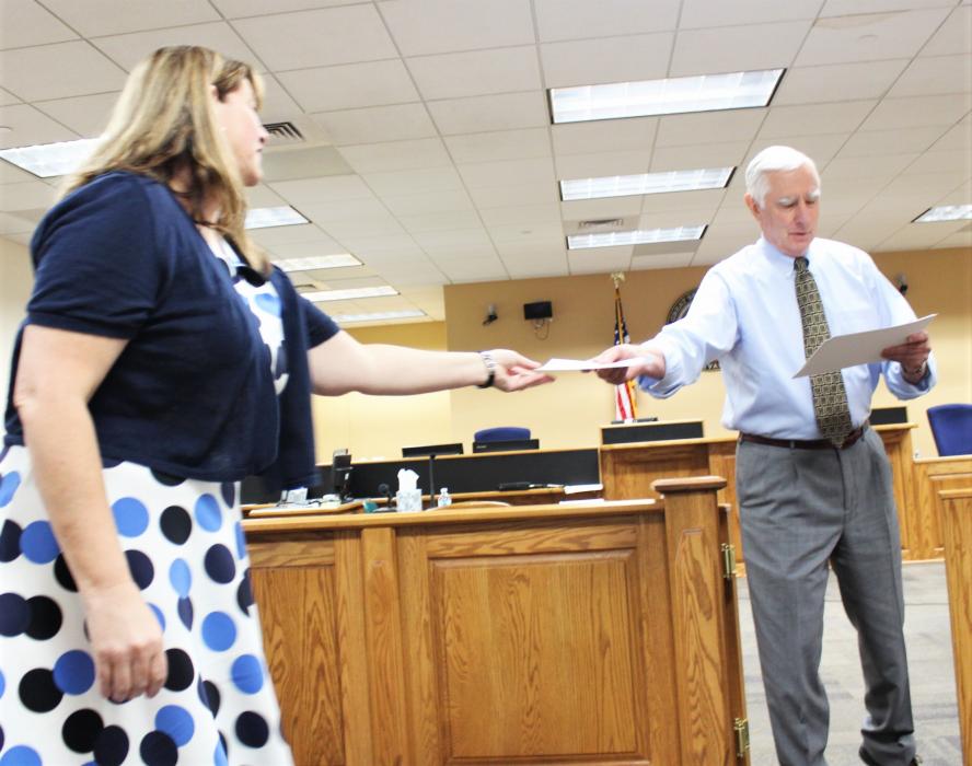 First Judicial District Court Judge James T. Russell hands a signed certificate to a guardian ad litem.