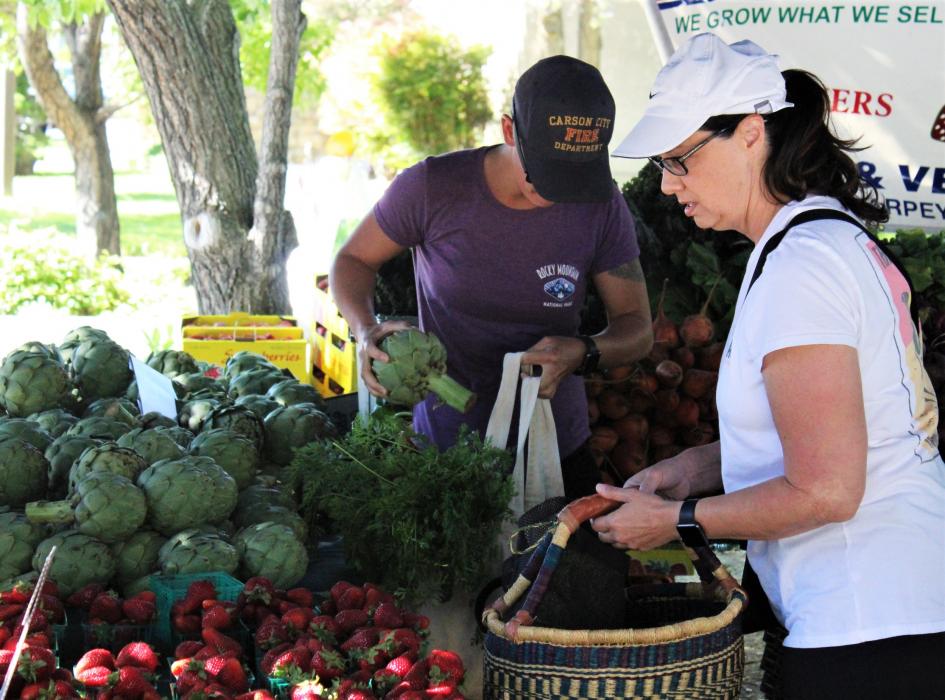 Customers select produce Saturday at the Third and Curry Farmer's Market.