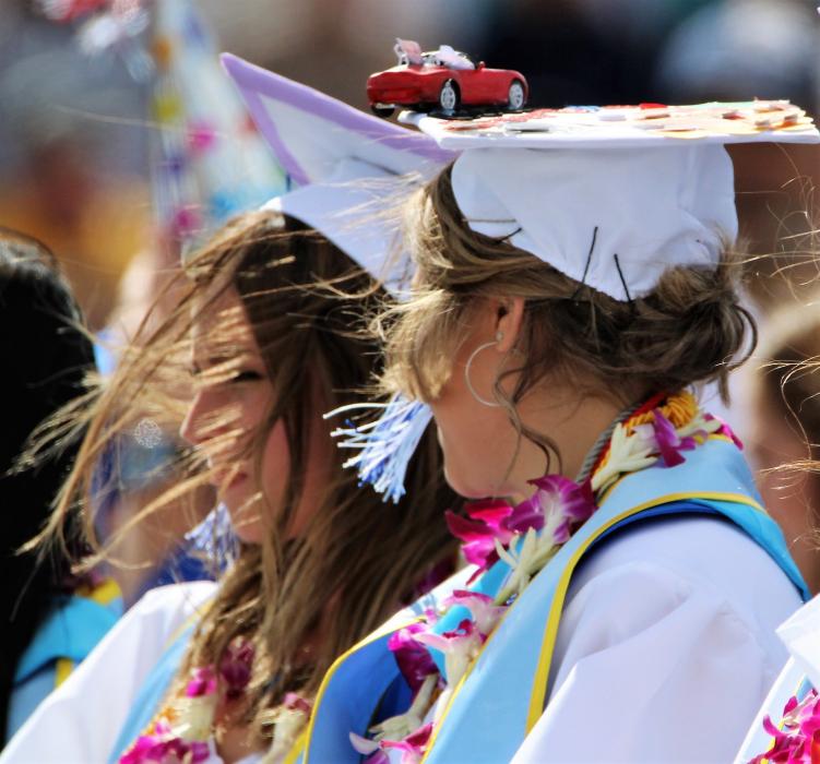 Windy conditions made it difficult for graduates to control hats and hair.