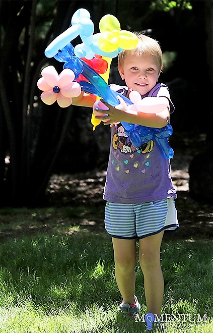 Rozallee Thompson, 5, carries a bouquet of balloons through the Secret Garden Sunday.