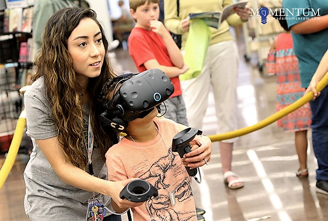 Zeke Jaramillo-Pettway, 7, tries virtual reality with the help of library staffer Jennyfer Llamas Sunday.