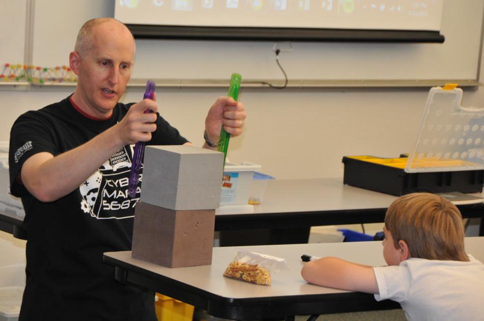 Robotics Camp instructor Scot Duncan leads a lesson as camper Don Winne listens.