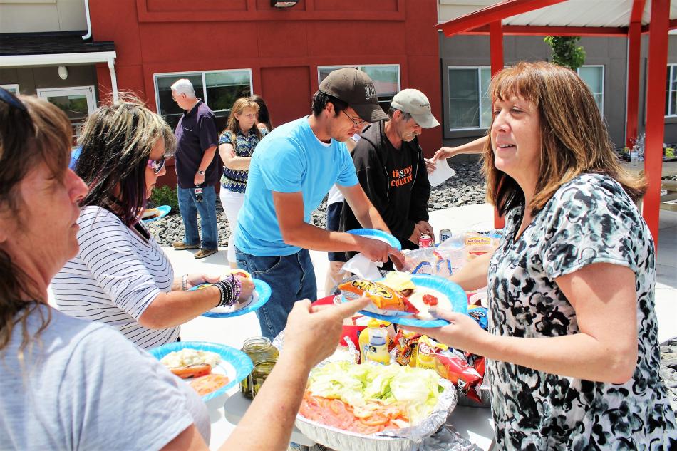 Photo by Brett Fisher. Residents and volunteers attend a barbecue Friday at Richards Crossing.
