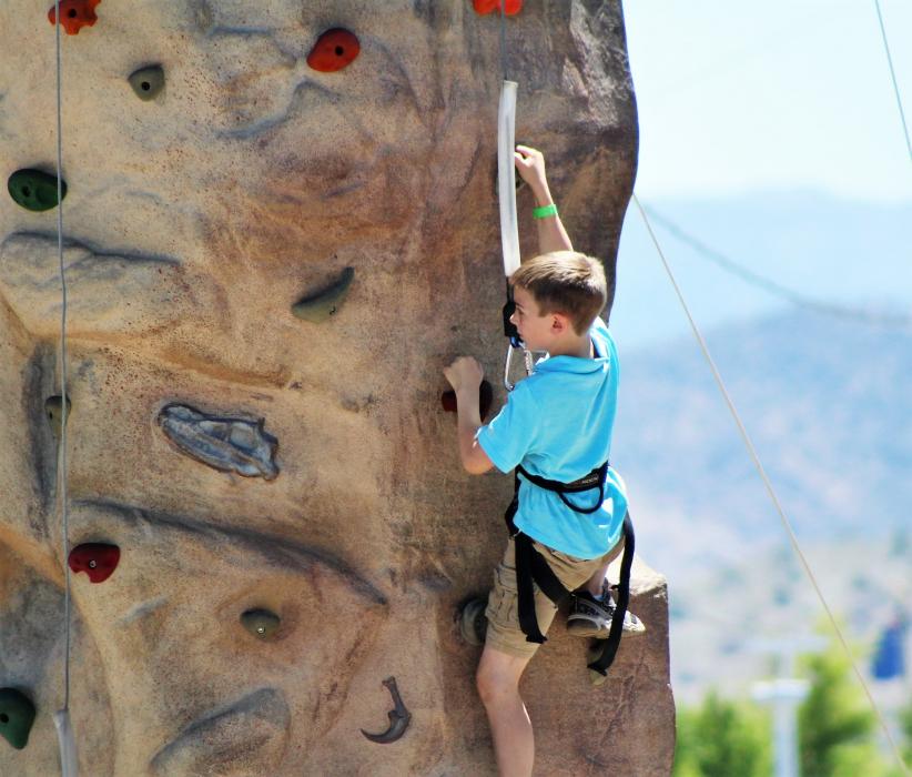 A boy climbs the rock wall Saturday at the Nevada Outdoor Experience.